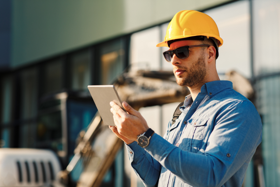 Construction site worker with a tablet in his hands